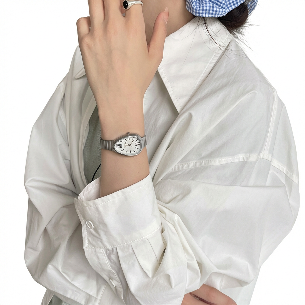 Person wearing a white shirt and a watch on a plain background
